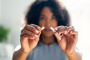 Woman breaking cigarette in half