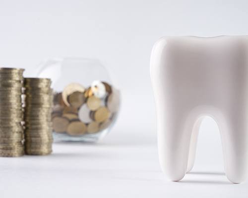 Pile of coins next to a tooth