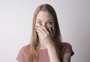 Young woman covering mouth with hand