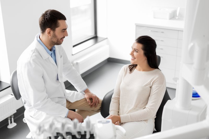  patient speaking with dentist about sensitive teeth with veneers 