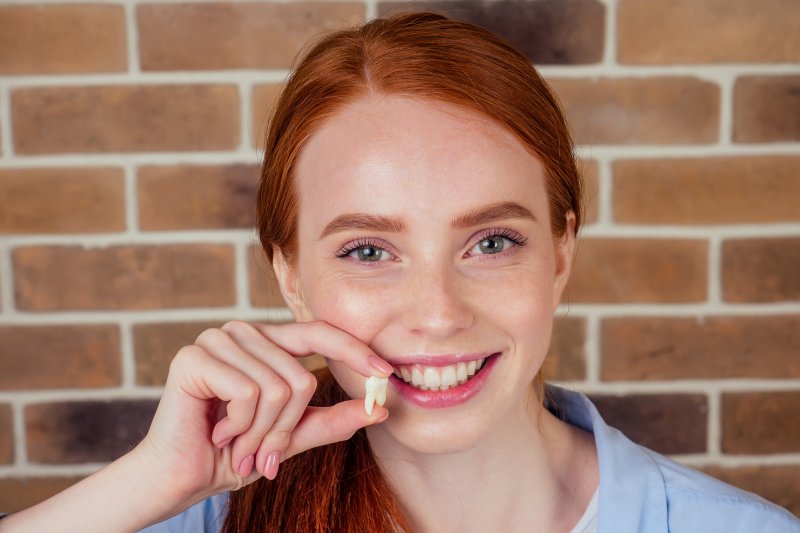 A woman holding her knocked-out tooth