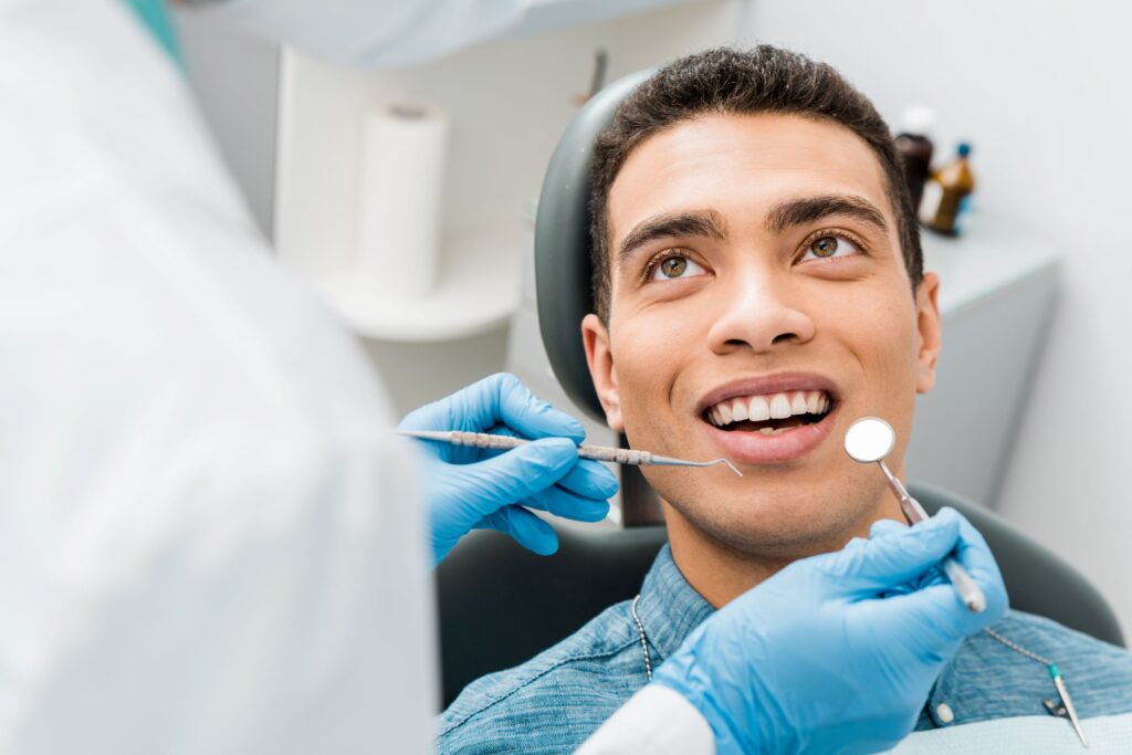 Man in dental chair smiling about to have an exam
