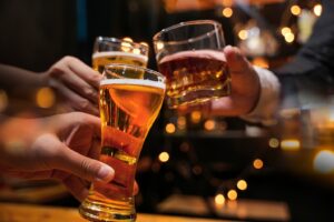 Three people toasting with alcoholic drinks.